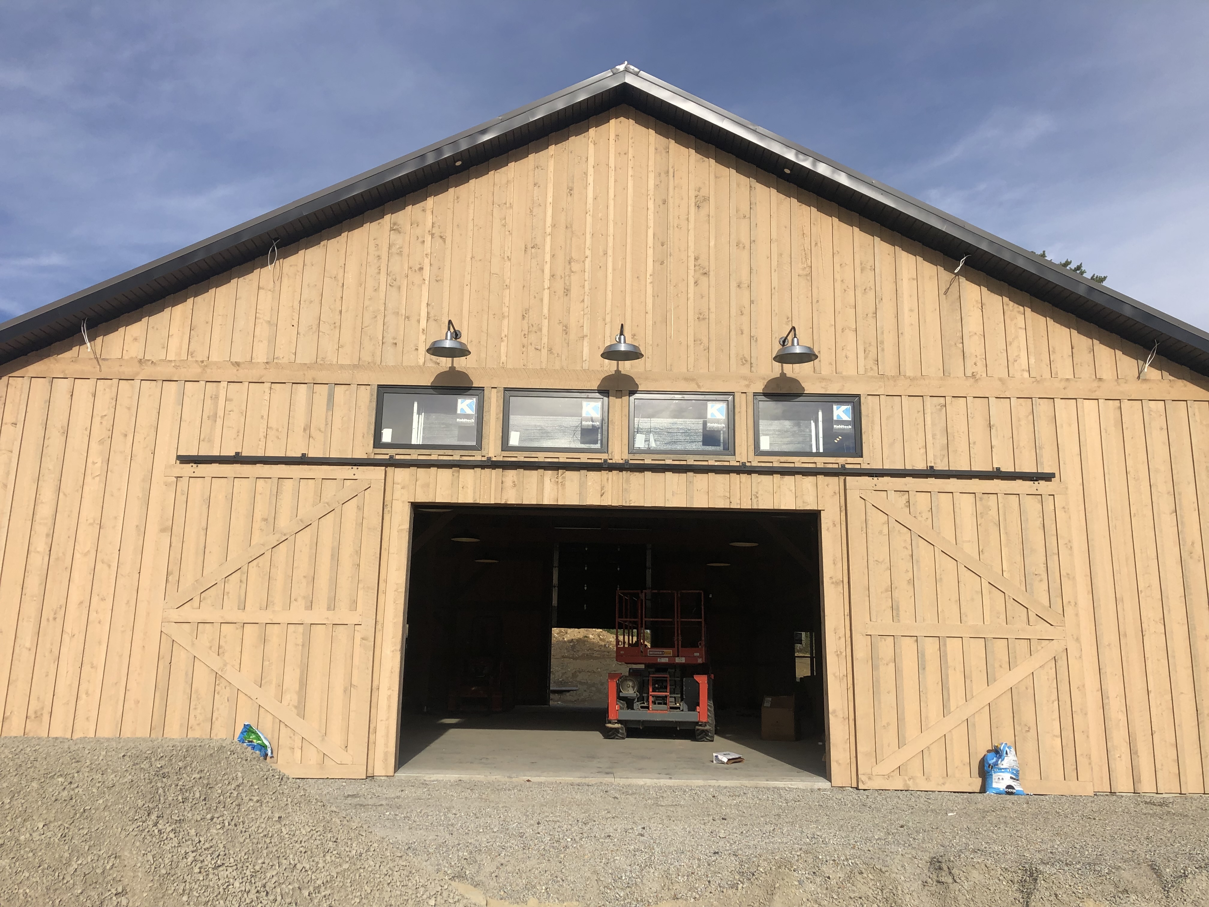 Exterior view of a high-end barn with overhead lighting installed above the main door